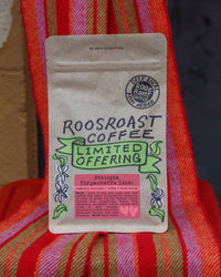 Roosroast coffee package on a colorful fabric background