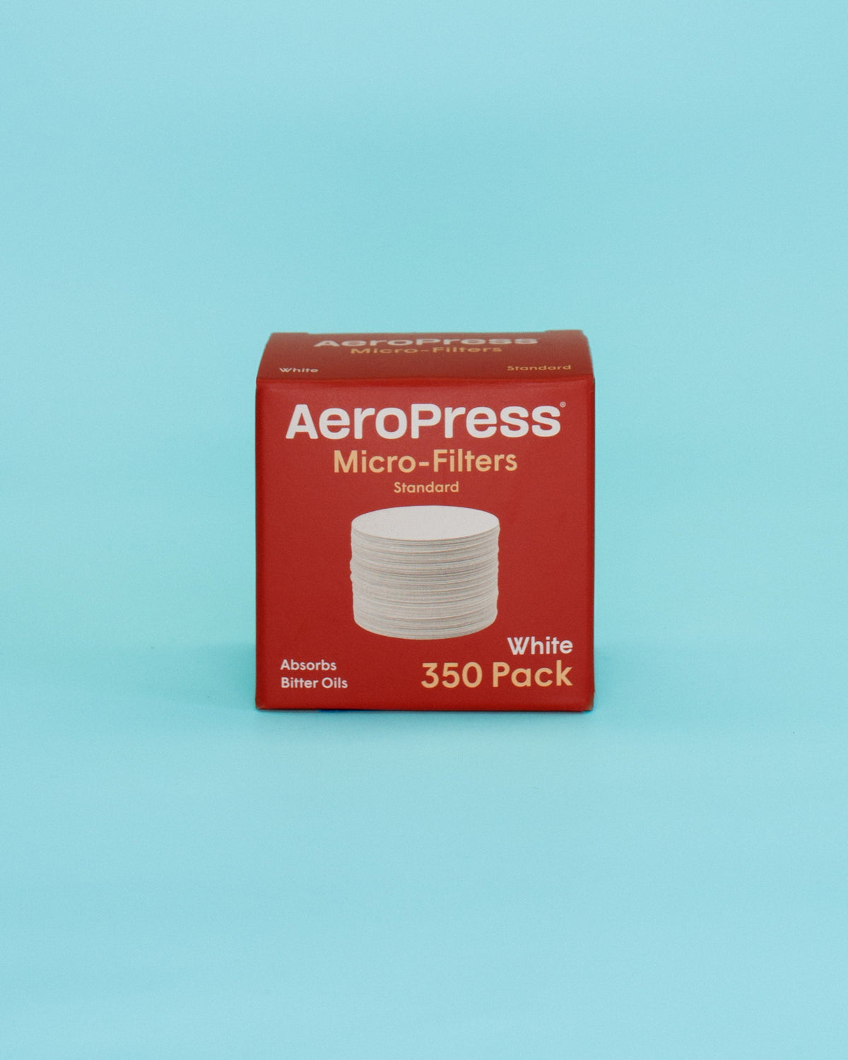 A red box of AeroPress Micro-Filters, Standard size, 350 pack, containing white circular filter discs, set against a solid light blue background.