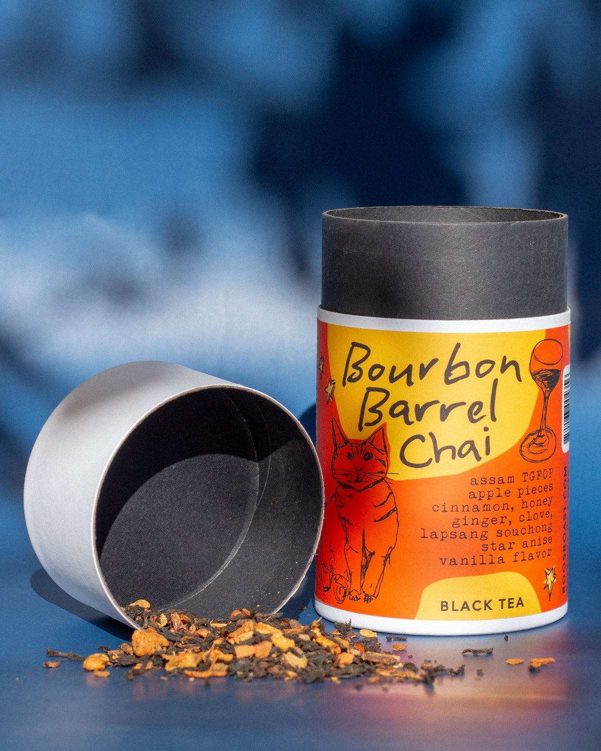 Bourbon Barrel Chai black tea canister with loose tea on a blue background