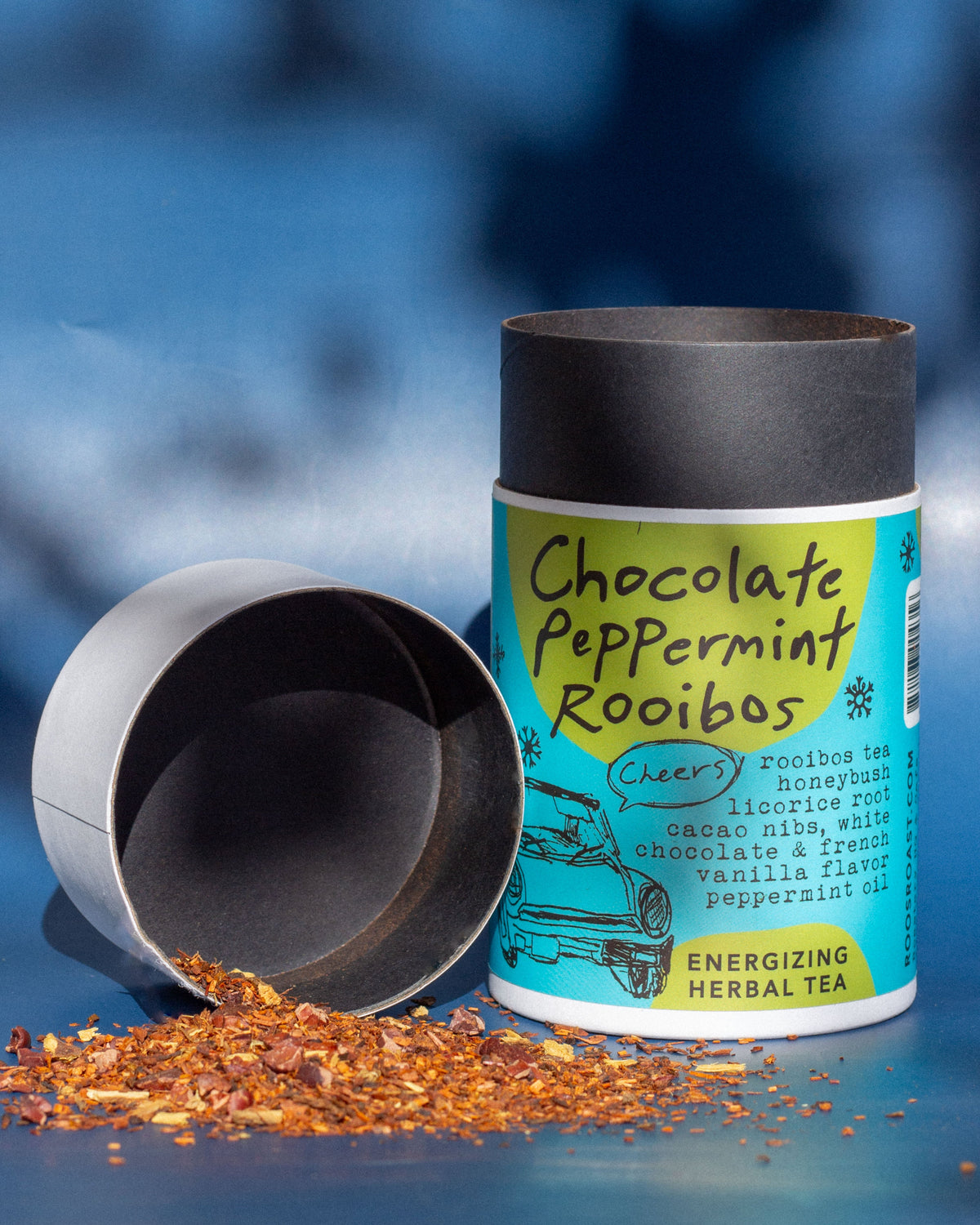 Tea canister labeled 'Chocolate Peppermint Rooibos' with tea leaves spilling out on a blue background