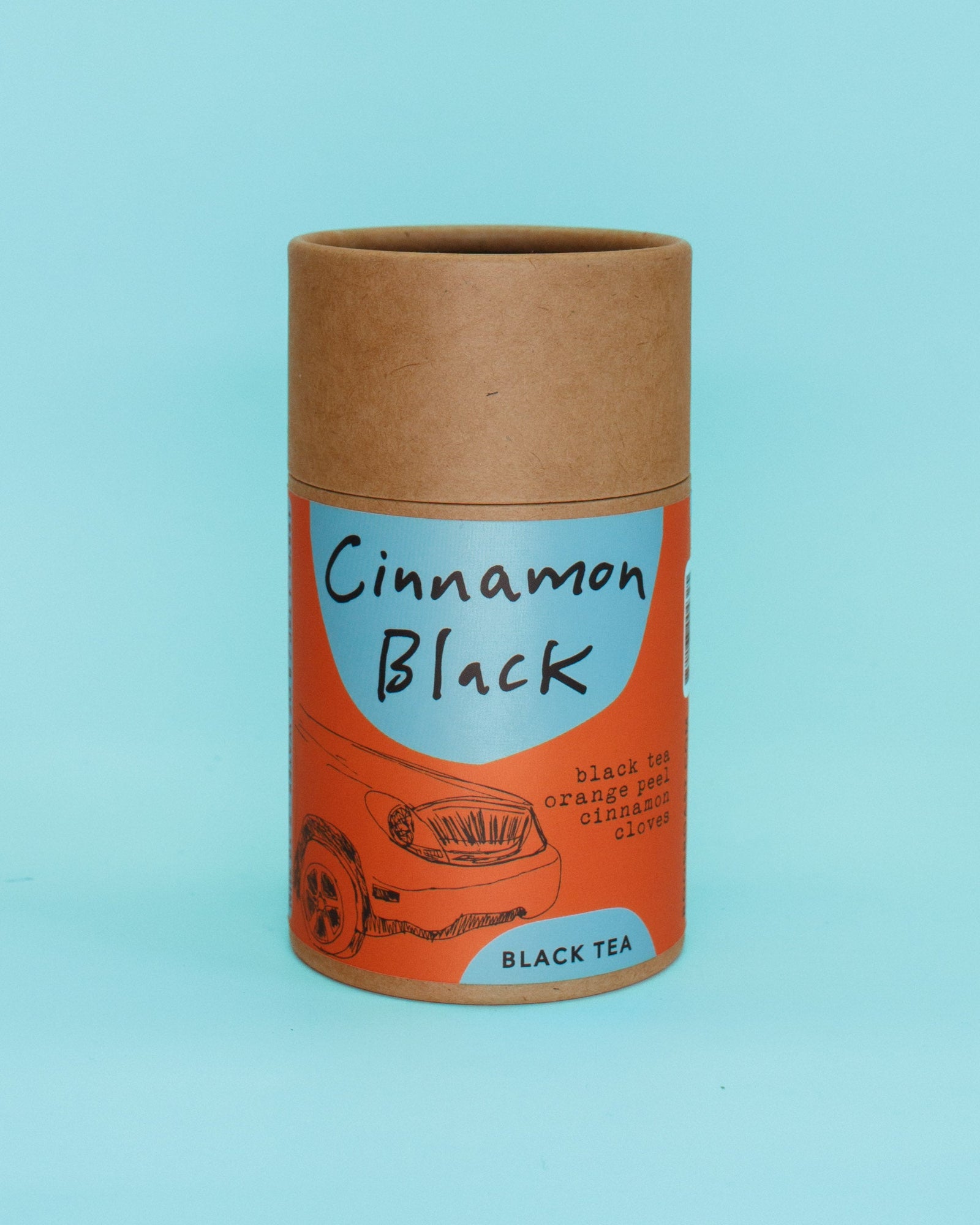 Cylindrical cardboard container with 'Cinnamon Black' tea packaging on a light blue background