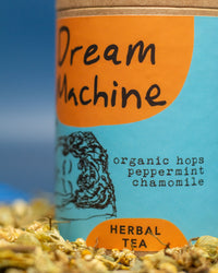 Tea packaging labeled 'Dream Machine' with herbs on a blue background