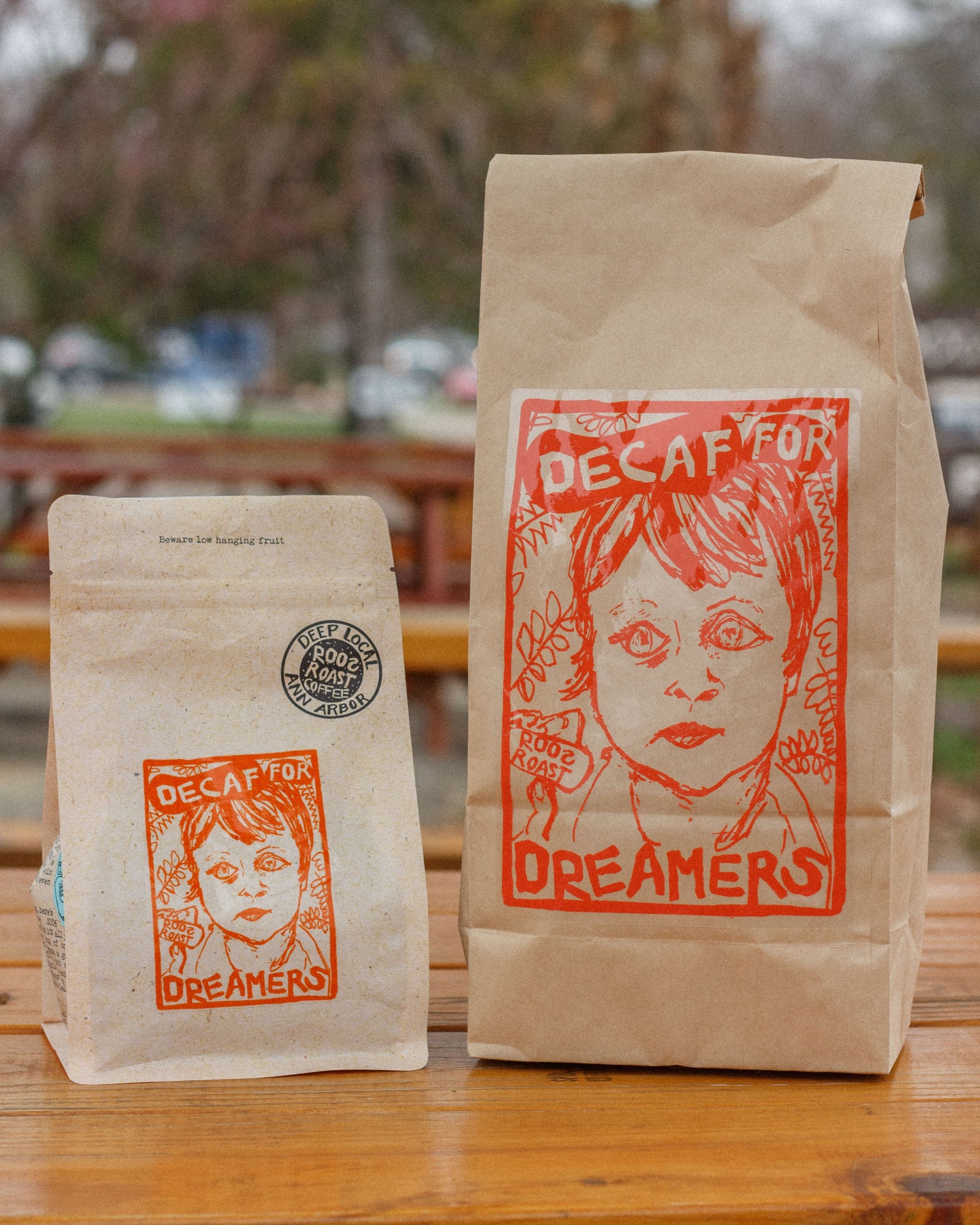 Two coffee bags with 'Decaf for Dreamers' design on a wooden surface.