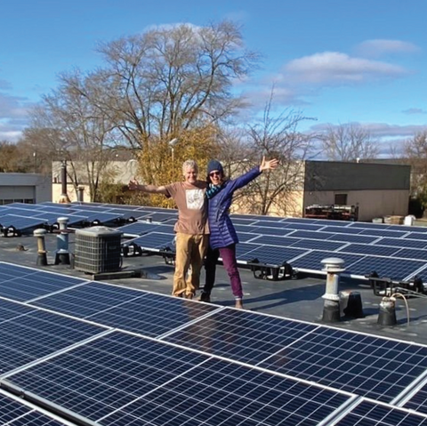 john and kath roos on roof of rosewood cafe with new solar panels