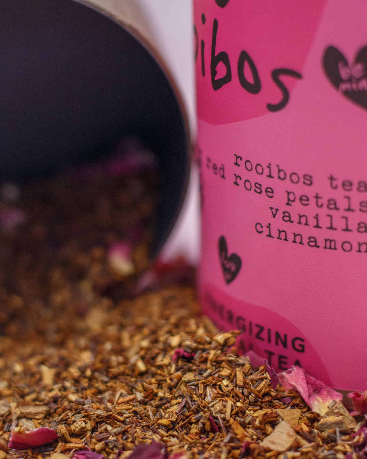Pink rooibos tea packaging with tea leaves spilling out