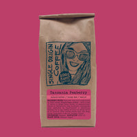 Kraft paper coffee bag with a graphic of a woman and text on a pink background