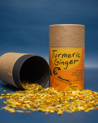 Turmeric Ginger herbal tea packaging with loose tea on a blue background